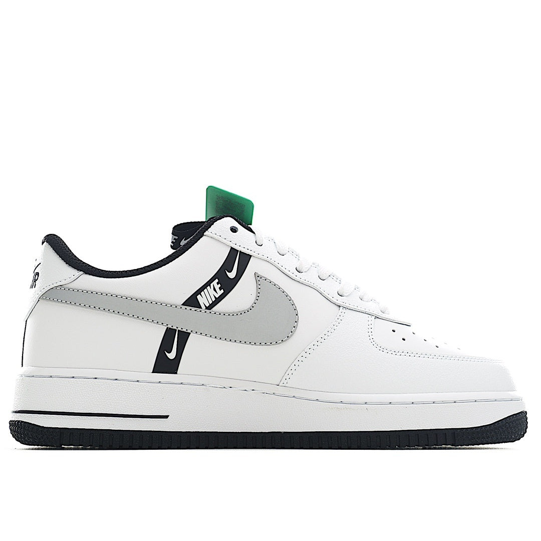 White Nike Air Force 1 sneakers with black swoosh and green collar tab.