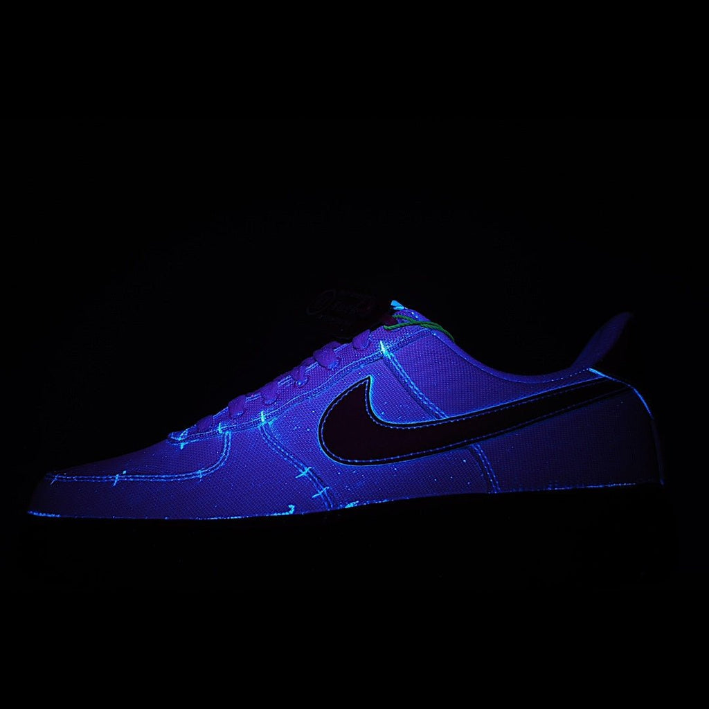Low-top sneaker in purple and black with neon blue swoosh