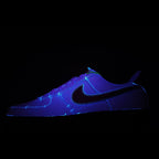 Low-top sneaker in purple and black with neon blue swoosh
