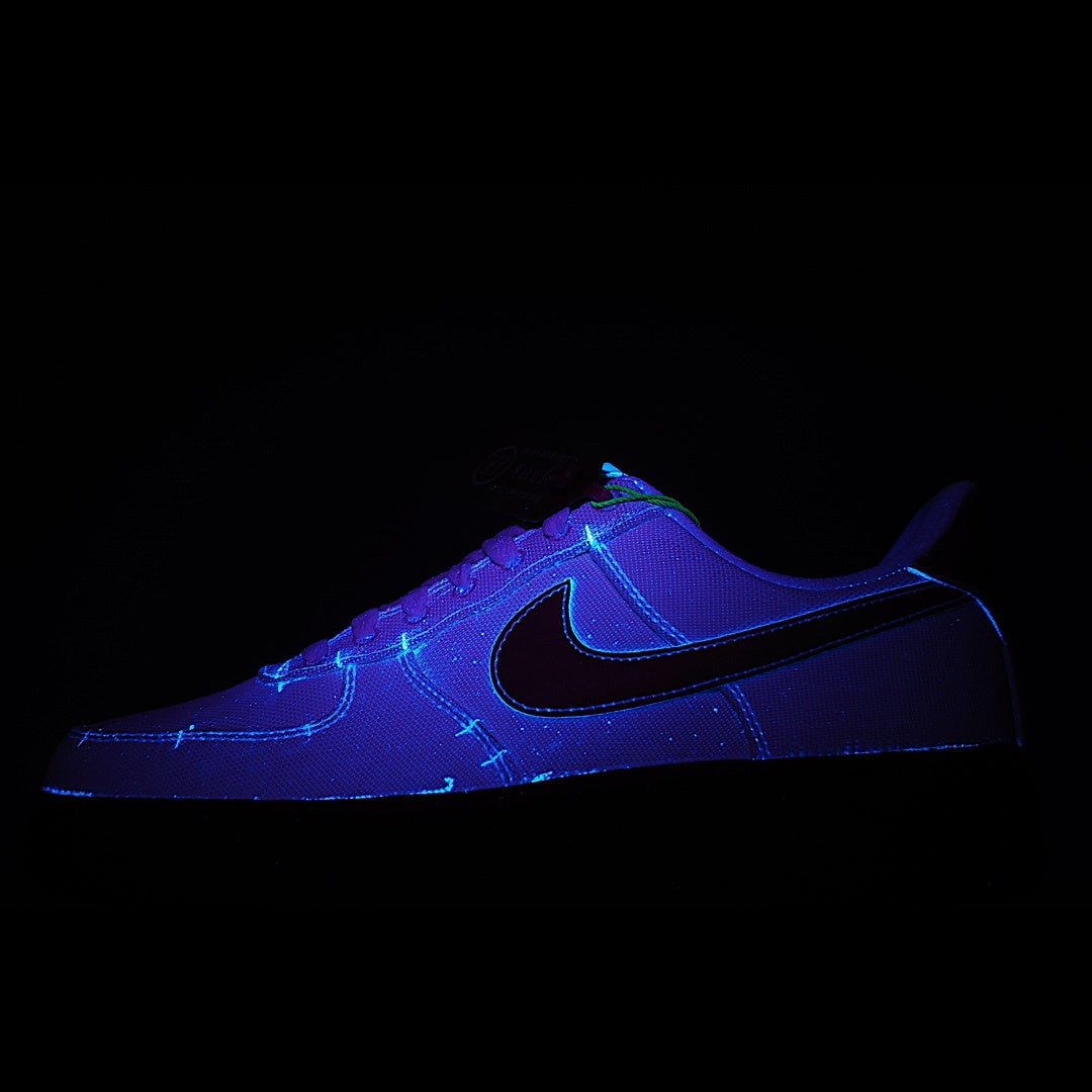 Low-top sneaker in purple and black with neon blue swoosh