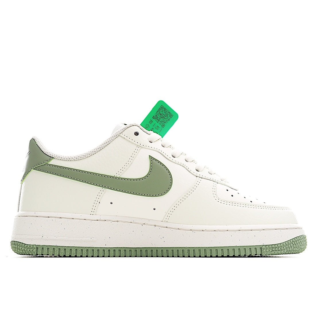 White leather sneaker with olive-green Swoosh overlay, perforated toe, and green tag