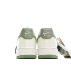 Pair of white sneakers with olive-green heel panel and Nike Air branding on back
