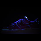 Dark blue low-top sneaker with black Swoosh and glowing blue trim