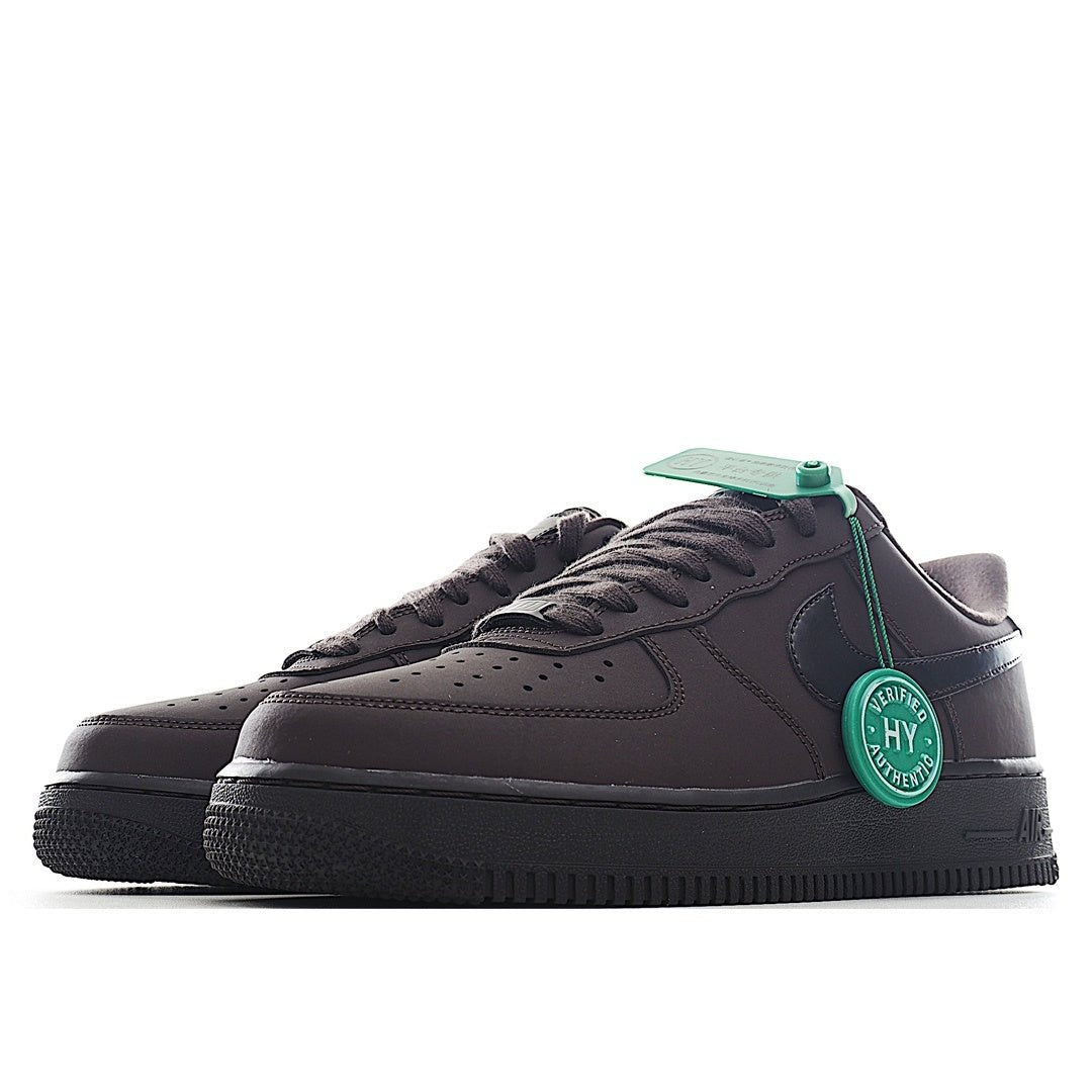Air Force 1 sneakers, dark upper with green heel badge and black lace-up front.