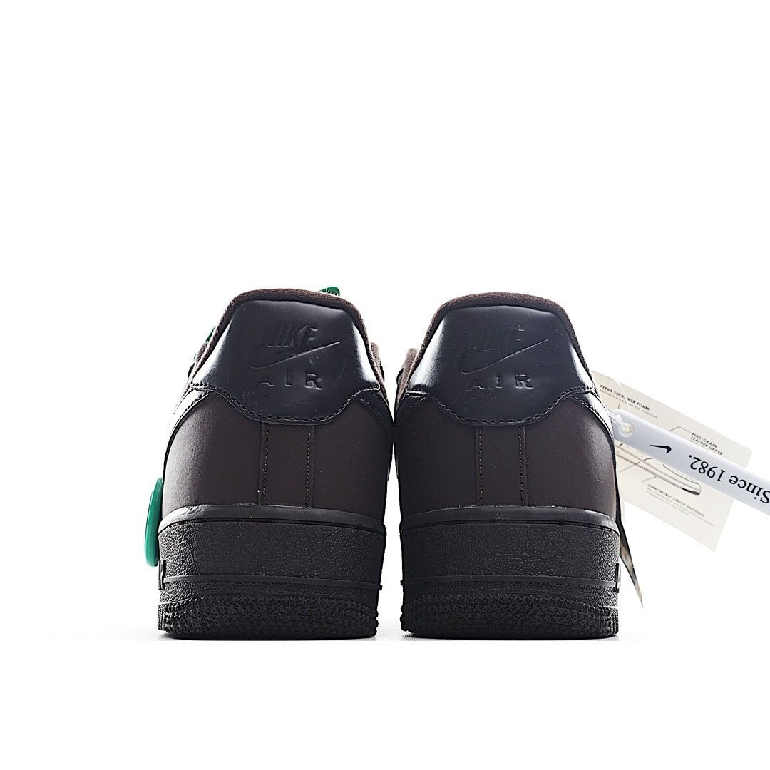 Air Force 1 sneakers, dark leather with green side detail at heel and rear pull tab.
