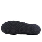 Air Force 1 outsole with dark traction tread and green accent on heel edge.