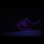 Dark low-top sneaker upper with purple glow lighting and visible swoosh