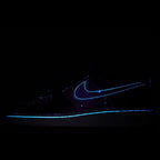 Dark sneaker with glowing blue Nike-style swoosh and small speckled details
