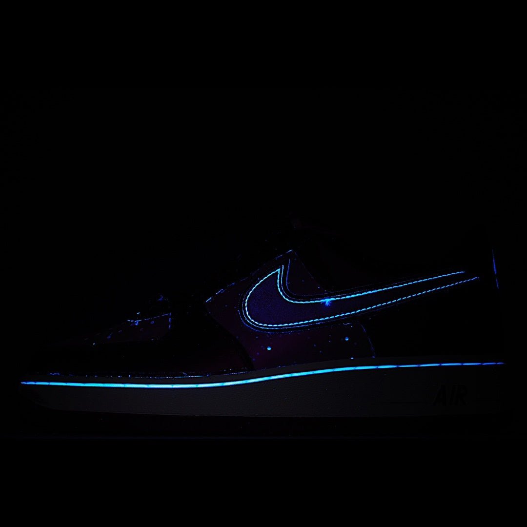 Dark sneaker with glowing blue Nike-style swoosh and small speckled details
