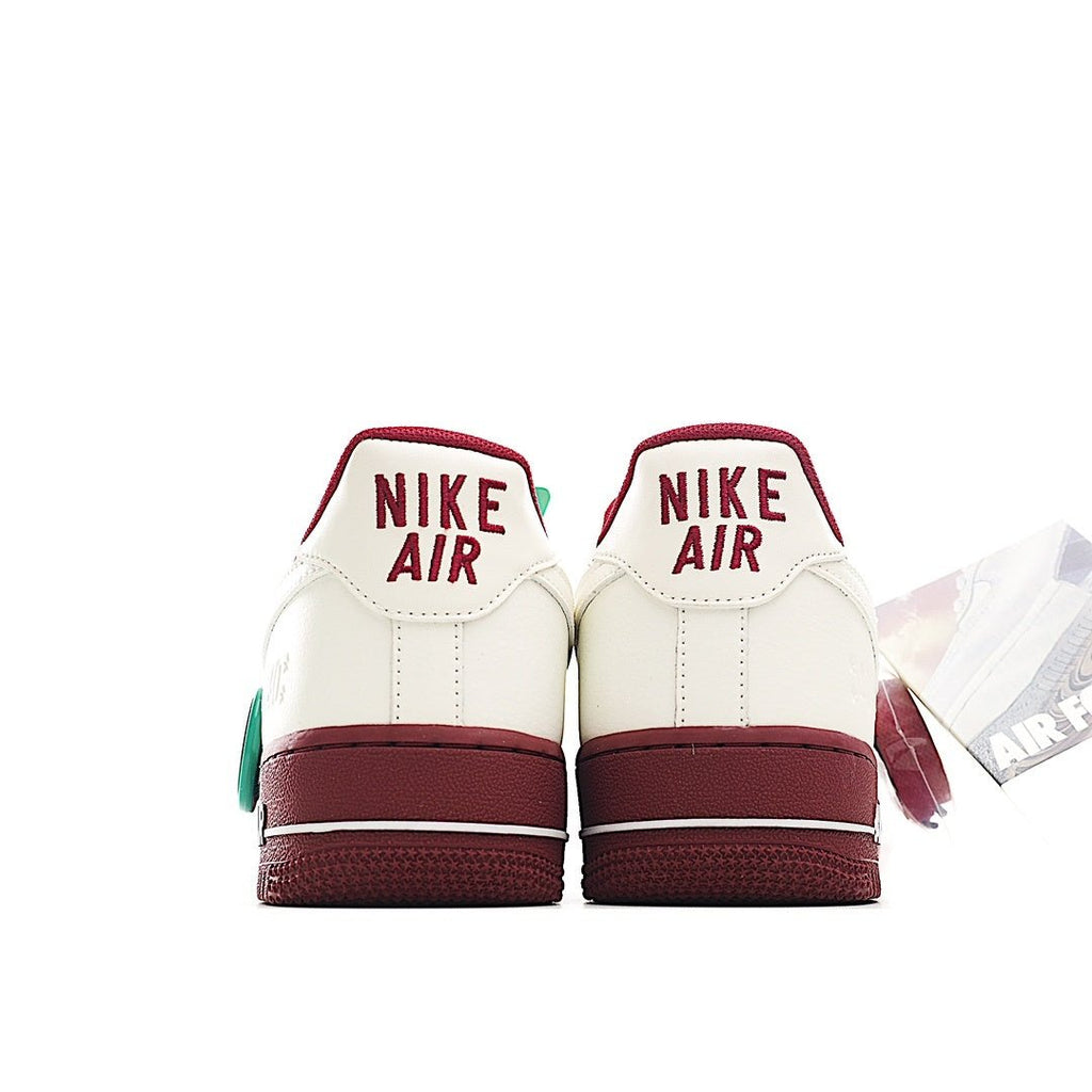 Pair of white Air Force 1 sneakers with burgundy heel panels and red Nike Air text