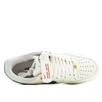 White low-top sneakers with green-trim collar and lace-up opening
