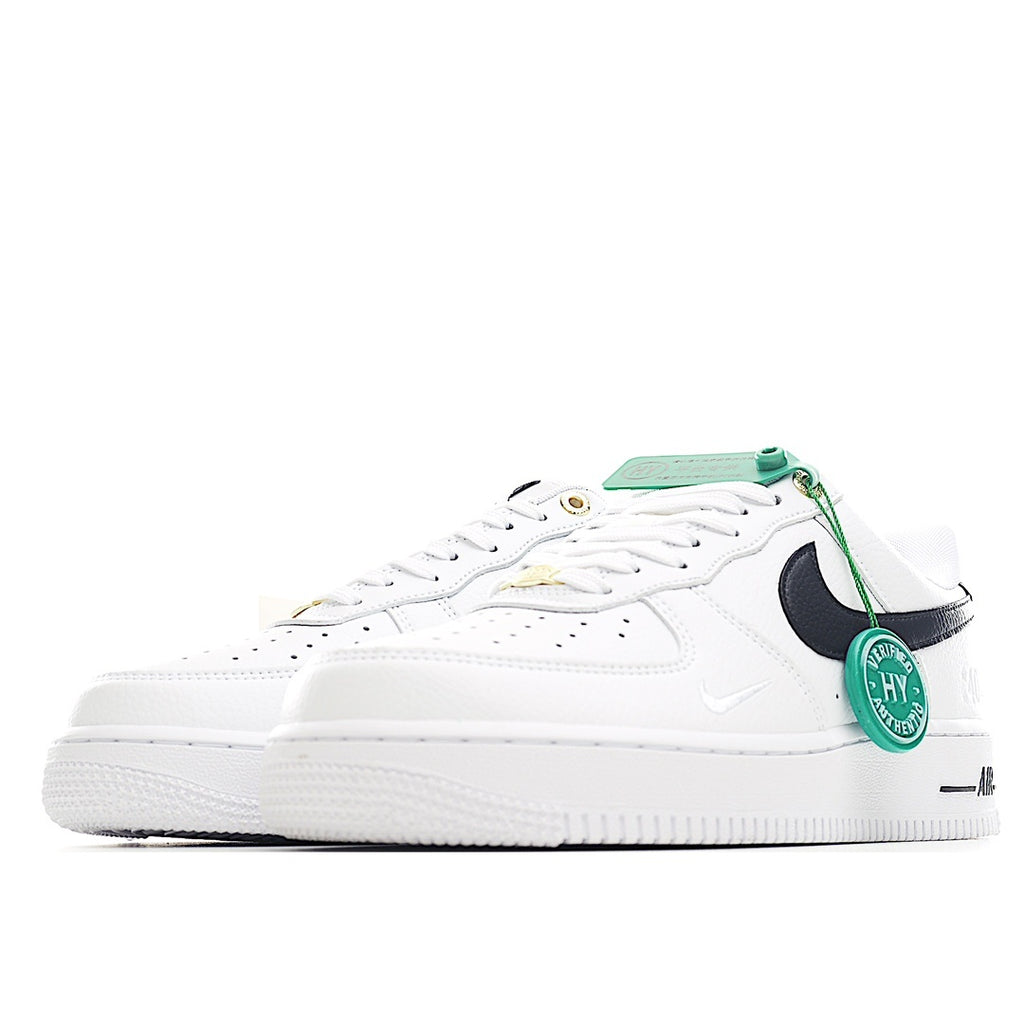 White leather sneaker side view with black swoosh, green laces, and perforated toe
