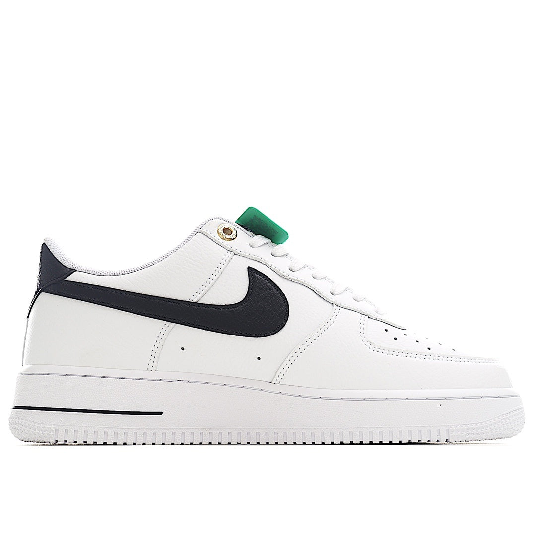 White leather sneaker with black swoosh and green collar pull tab