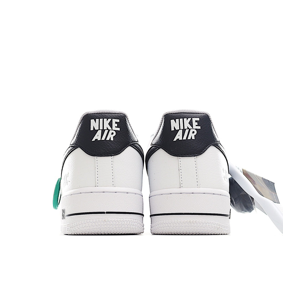 White sneaker heel pair with black Nike Air panels and green side lace tag