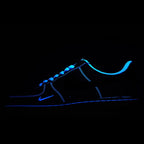Low-top sneaker with blue neon outline and dark upper