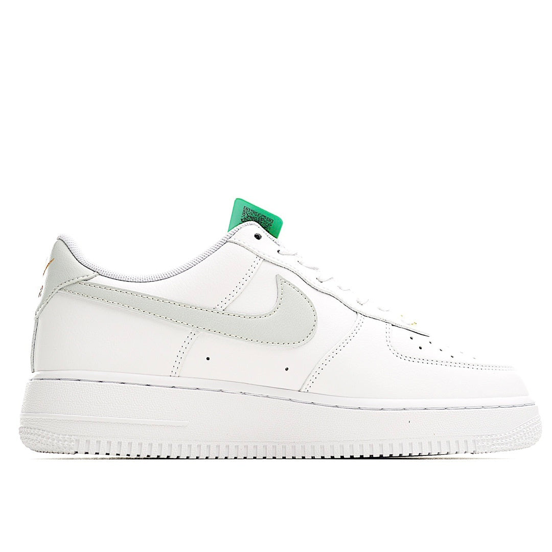 White Nike Air Force 1 sneakers with green collar tab and perforated toe