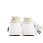 White Nike Air Force 1 sneakers with green heel pull tab and Air branding on the back