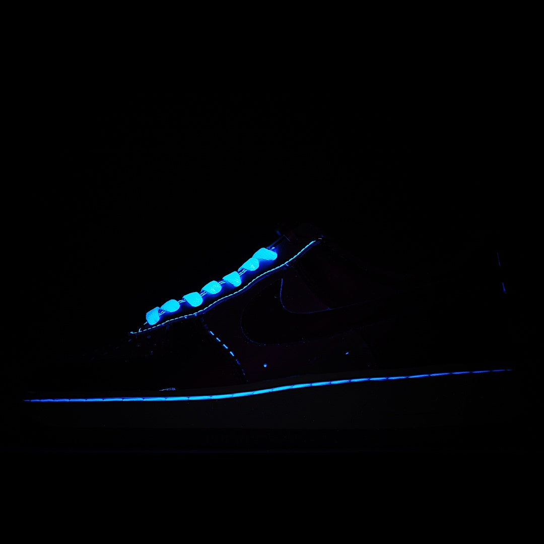 Dark blue sneaker with glowing blue trim and swoosh detail