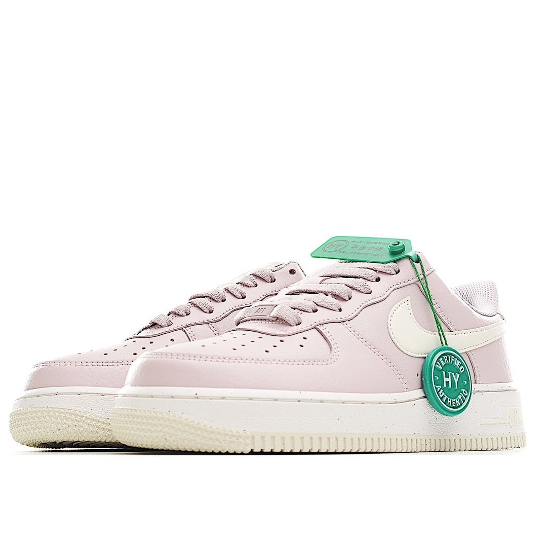 Pink low-top sneaker side view with green lace tag and white swoosh