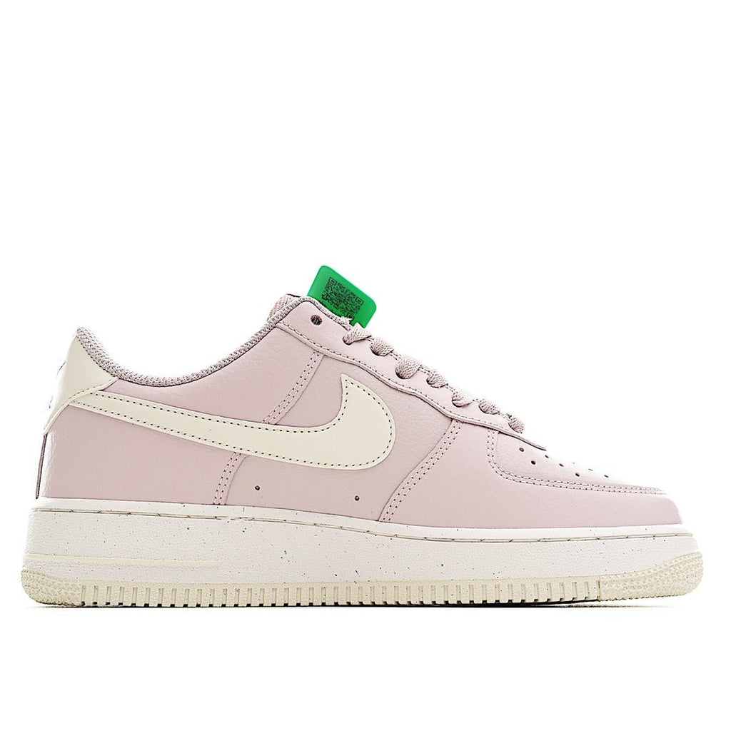 Pink low-top sneaker with green lace holder, white overlays, and perforated toe