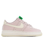 Pink low-top sneaker with green lace holder, white overlays, and perforated toe