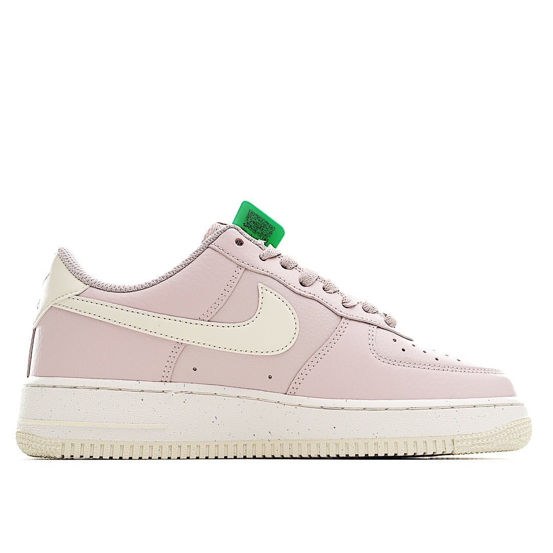 Pink low-top sneaker with green lace holder, white overlays, and perforated toe