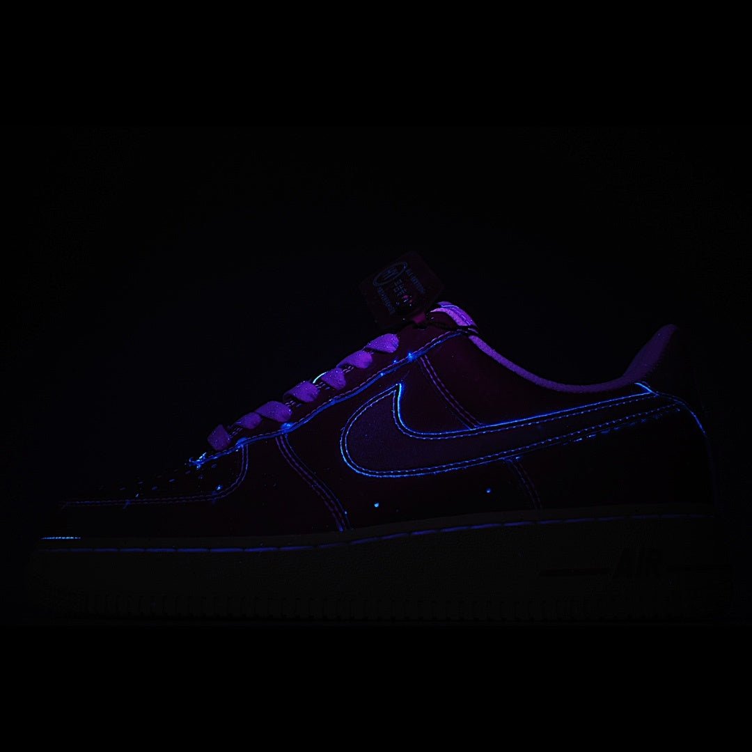Dark blue sneaker with neon blue stitching and purple glow accents