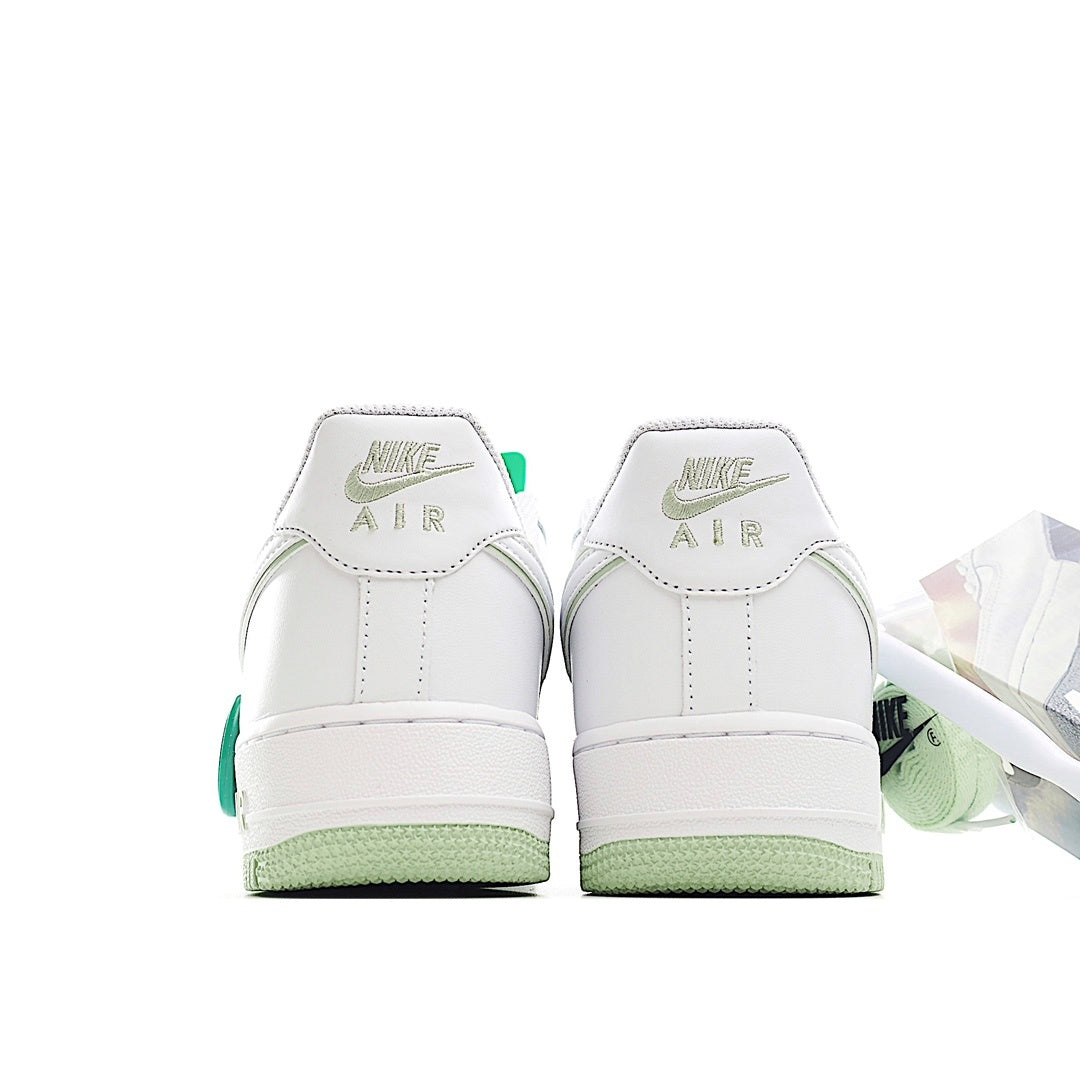 White Air Force 1 sneakers with green heel pull tabs and AIR branding on backs