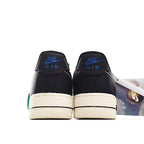Black low-top sneakers, cream sole, blue “AIR” logo on heel tab