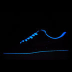 Dark sneaker with blue laces and blue-lit outline, low-top style