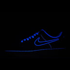 Low-top sneakers with blue laces, dark blue upper and glowing blue swoosh