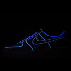 Black low-top sneaker with blue neon outline and lace-up design