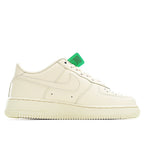 Cream leather low-top sneaker with white laces and green neck tag, stitched panels