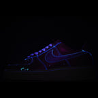 Dark low-top sneaker with blue neon-style stitching and laces