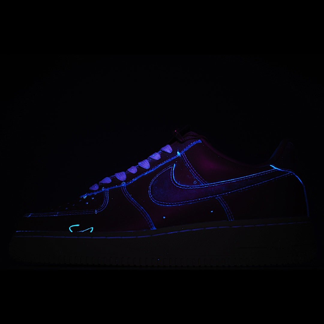 Dark low-top sneaker with blue neon-style stitching and laces