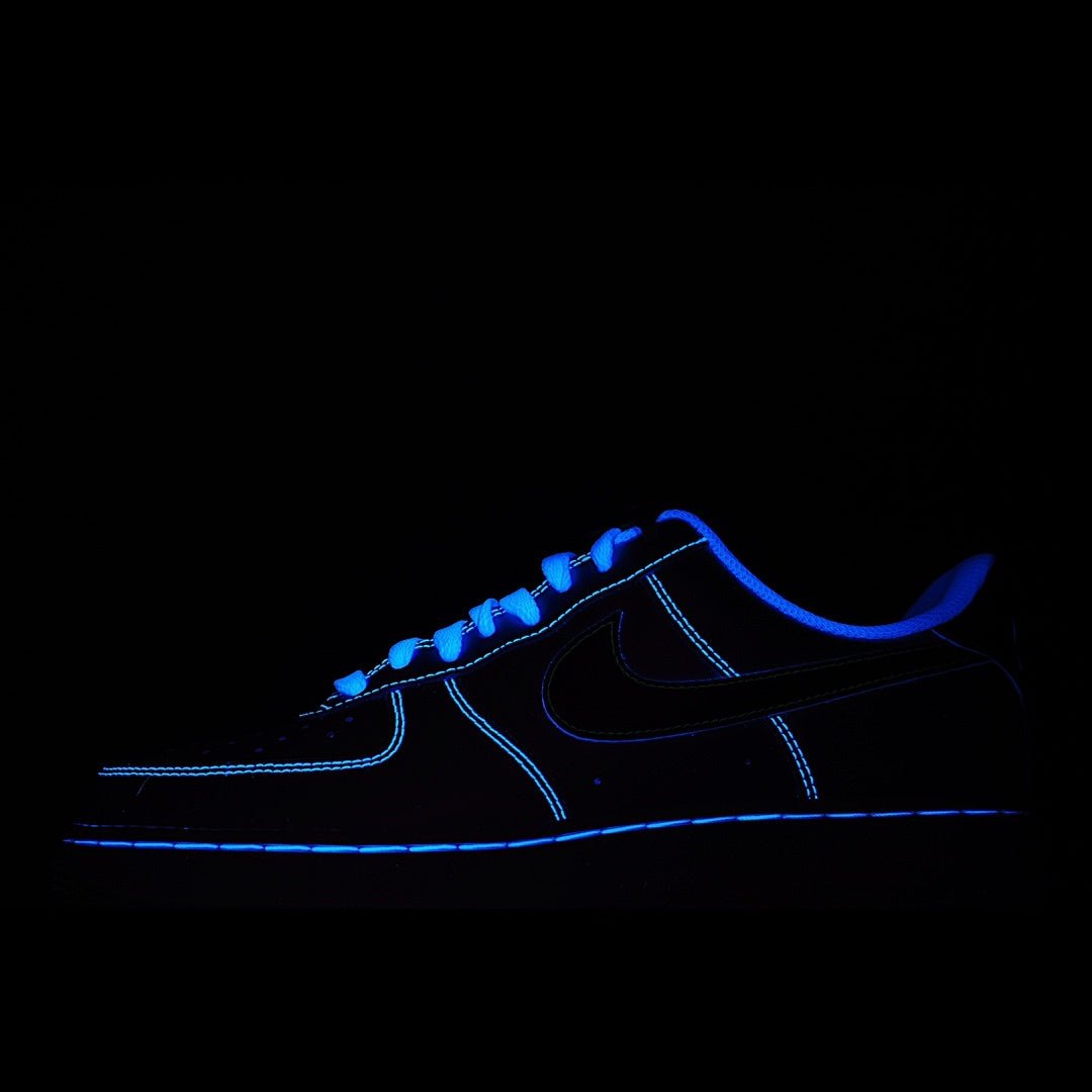 Low-top sneakers, dark upper with blue glowing outline and lace details