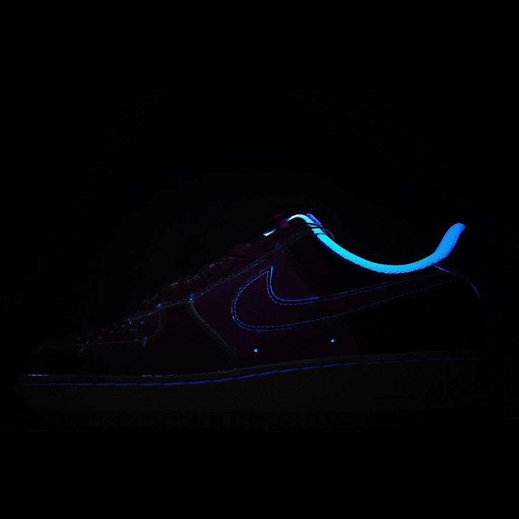 Dark sneakers with blue glowing swoosh and stitching details