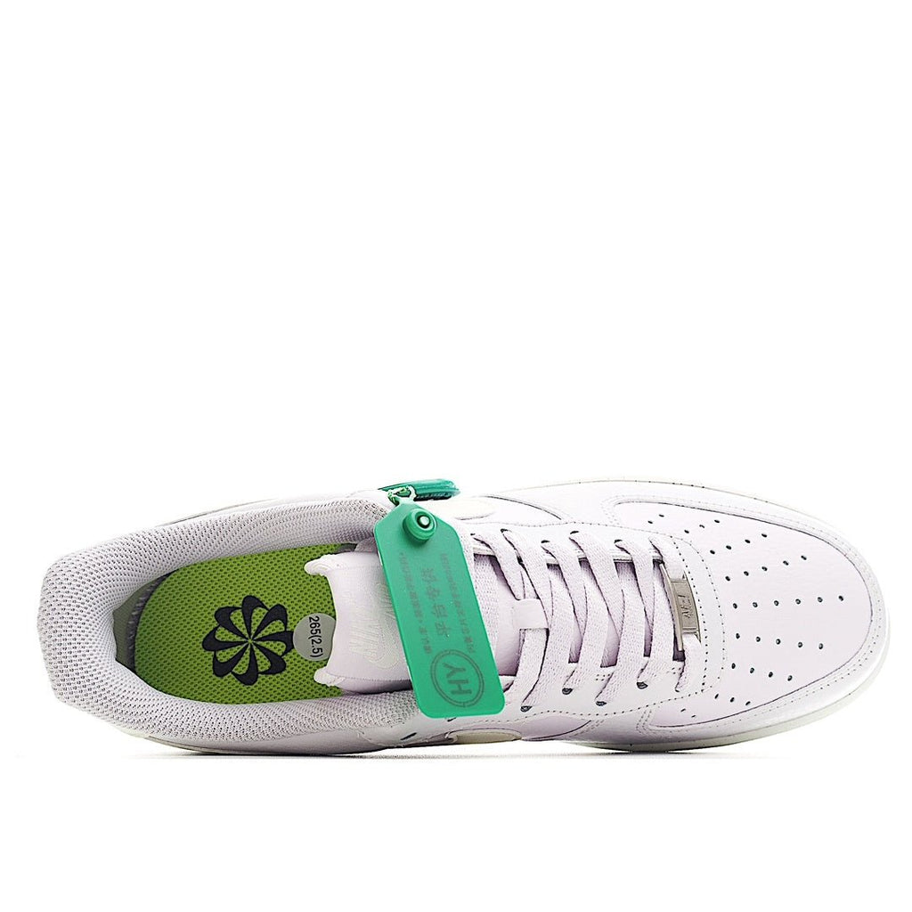 White low-top sneakers showing green inner lining and lace-up eyelets
