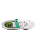 White low-top sneakers showing green inner lining and lace-up eyelets