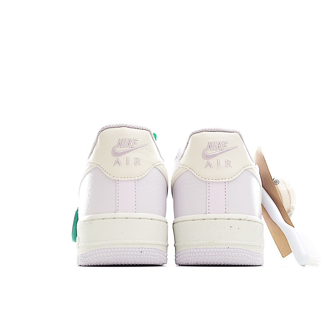 White low-top sneakers with green heel pull tab and Nike Air heel detail