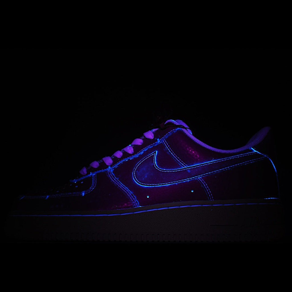 Dark blue low-top sneakers with glowing neon-style trim and lace-up front