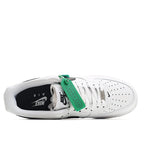 White low-top sneaker with green lace tabs, perforated toe, inside view