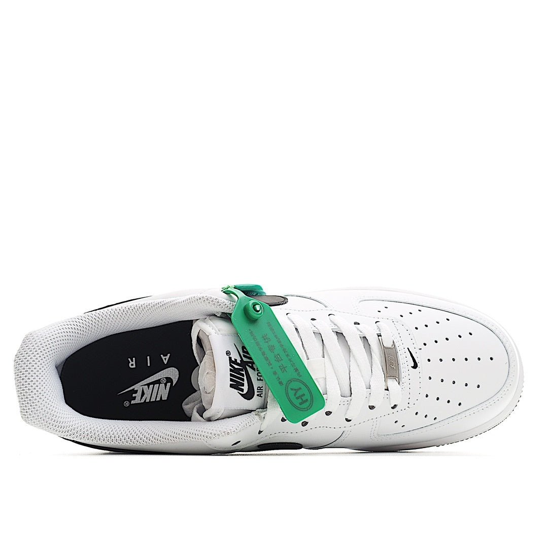 White low-top sneaker with green lace tabs, perforated toe, inside view