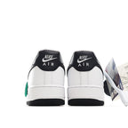 Pair of white sneakers with black heel collars and green lace accents, back view