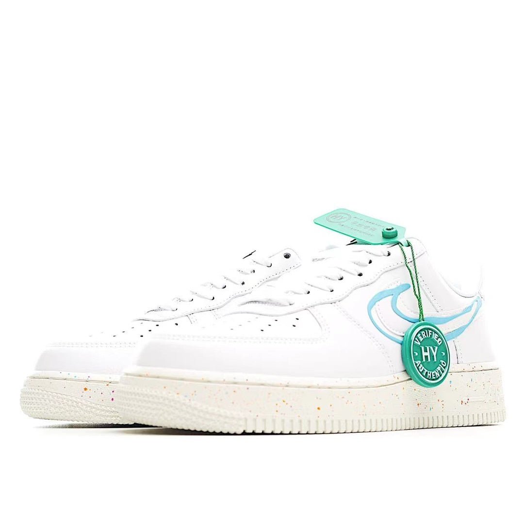 White low-top sneakers with light blue swoosh, green tag, and speckled midsole