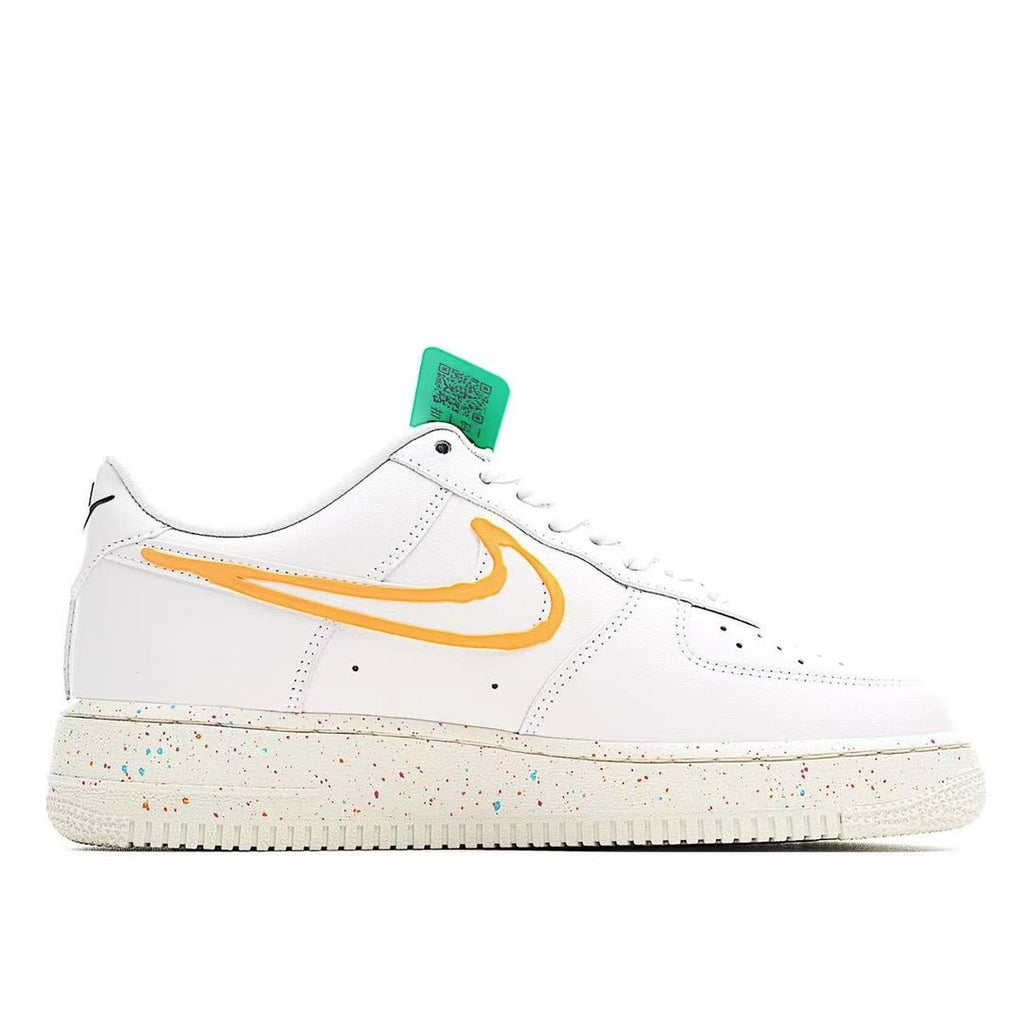 White low-top sneakers with orange swoosh, green hang tag, and speckled sole