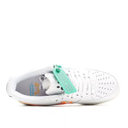 White low-top sneakers with green tag and blue graphics inside, speckled outsole
