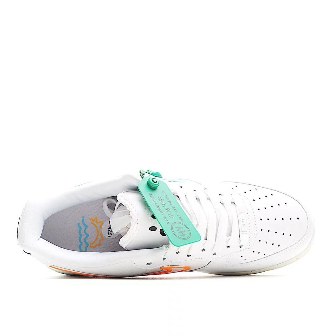 White low-top sneakers with green tag and blue graphics inside, speckled outsole