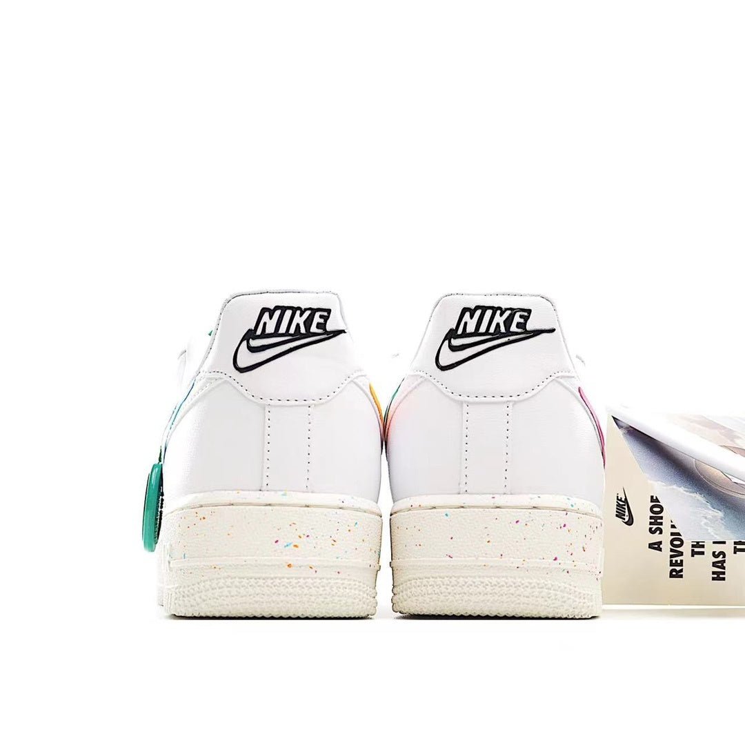 White low-top sneakers with black Nike heel text, speckled sole, teal lace accents