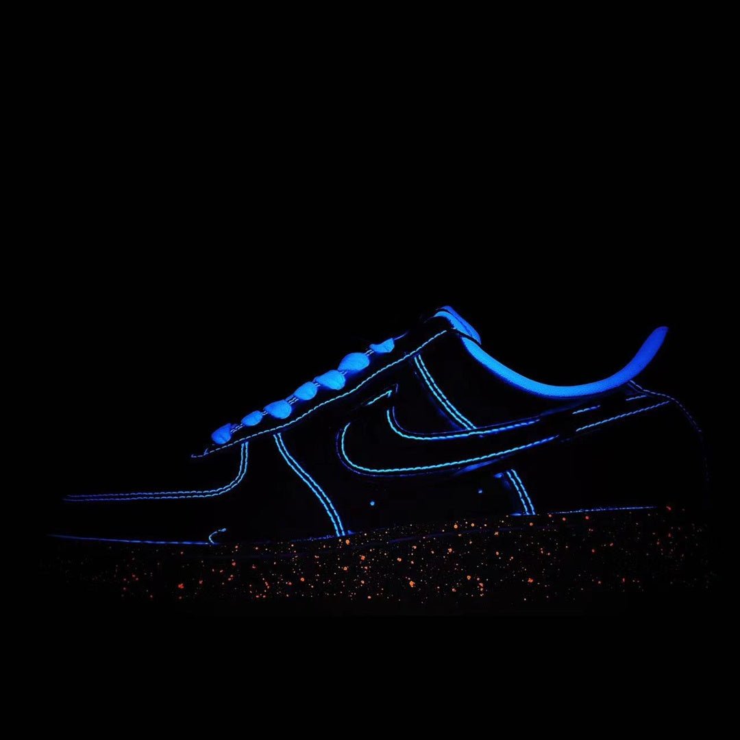Low-top sneakers with dark upper and blue swoosh accents, speckled outsole